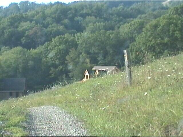 Roof of house appears over hill